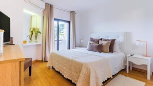 Une chambre à coucher avec un lit, une table de chevet, une lampe et une fenêtre avec des rideaux.