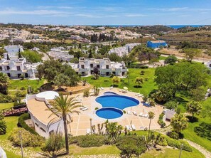 Ein Resort mit einem großen Schwimmbad, mehreren Gebäuden und Blick auf die umliegende Landschaft.