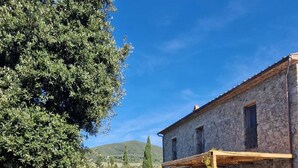 Un edificio in pietra con un portico coperto e posti a sedere all'aperto.