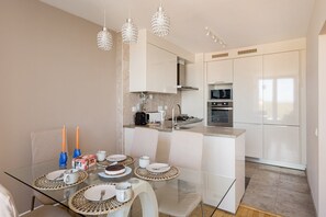 A modern kitchen with white cabinets, a built-in oven, and a microwave. - Cascais Prime 2BR with Balcony & Sea View (Cascais)