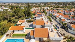 Ein Wohngebiet mit Häusern, die rote Ziegeldächer und einen Swimmingpool haben.
