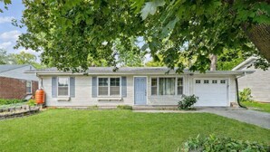 A single-story house with a front porch, a garage, and a well-maintained lawn.