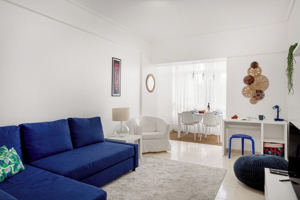Living room with a comfortable chaise-longue sofa, TV and work desk.