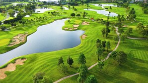 A golf course with multiple water hazards, sand bunkers, and a well-maintained green. - Central Albufeira Stay | Balcony & AC (Albufeira)