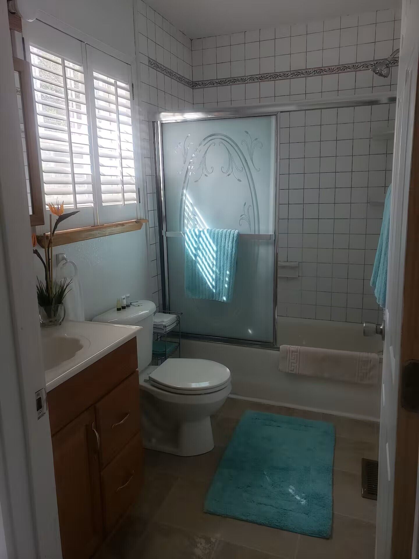 A bathroom with a toilet, sink, and shower area.