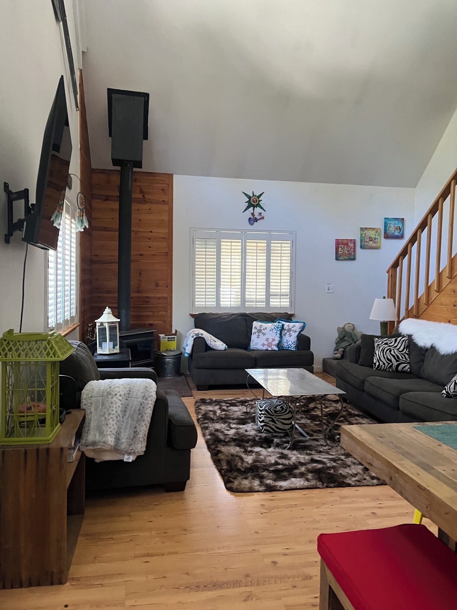 A cozy living room with a fireplace, two sofas, a coffee table, and a staircase.