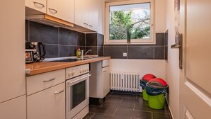 A compact kitchen with a window, a stove, and a sink.