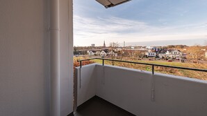 A balcony with a view of a town, including houses and a church.