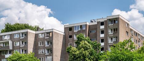 A multi-story residential building with balconies, windows, and a clear sky.