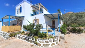 A two-story building with a white exterior, blue accents, and a stone foundation.