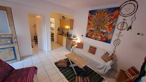 A living room with a sofa, a coffee table, and a painting on the wall. - 'Fun' with Shared Garden and Wi-Fi (Syros)