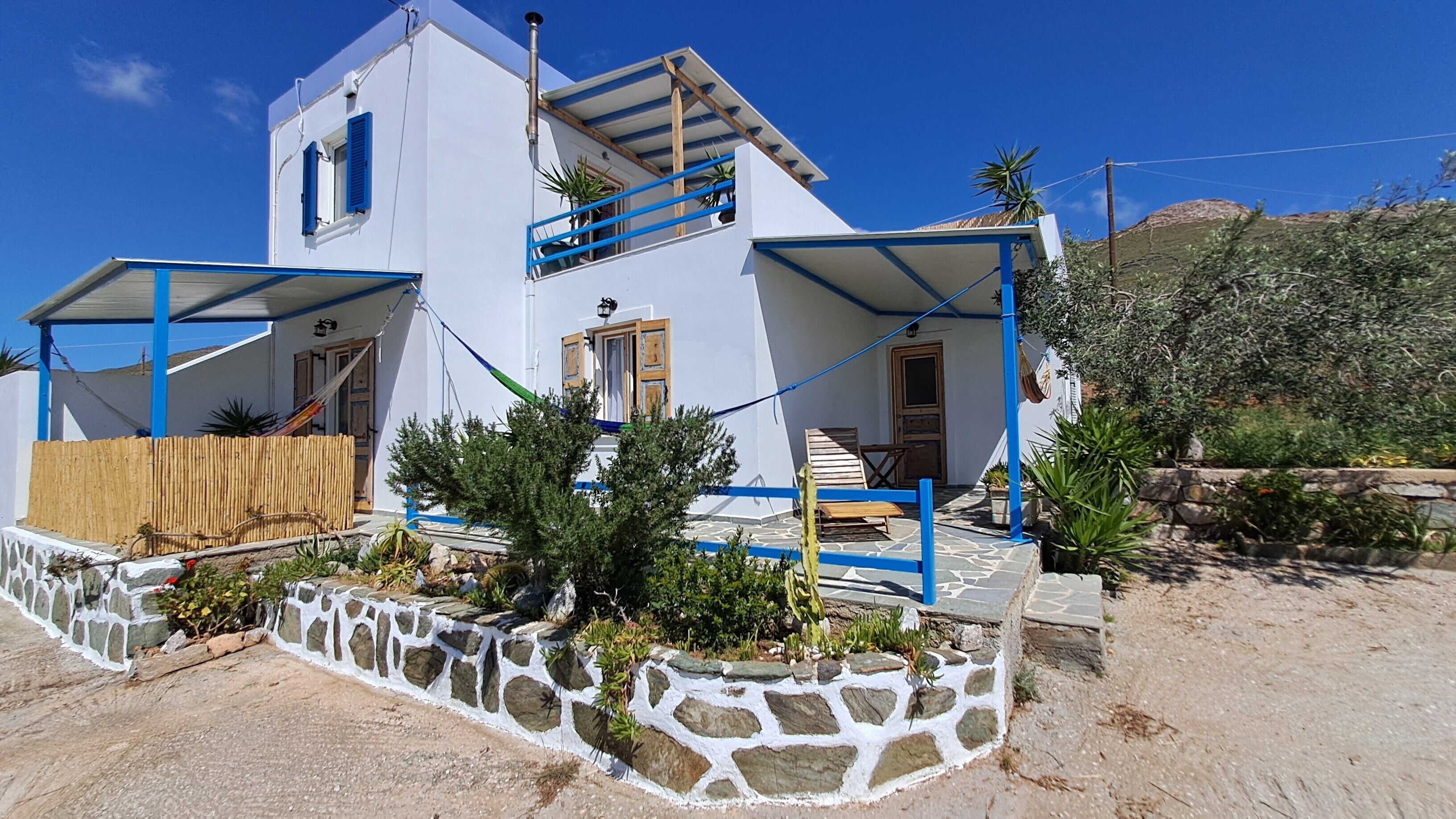 A two-story building with a white exterior, blue accents, and a stone foundation.