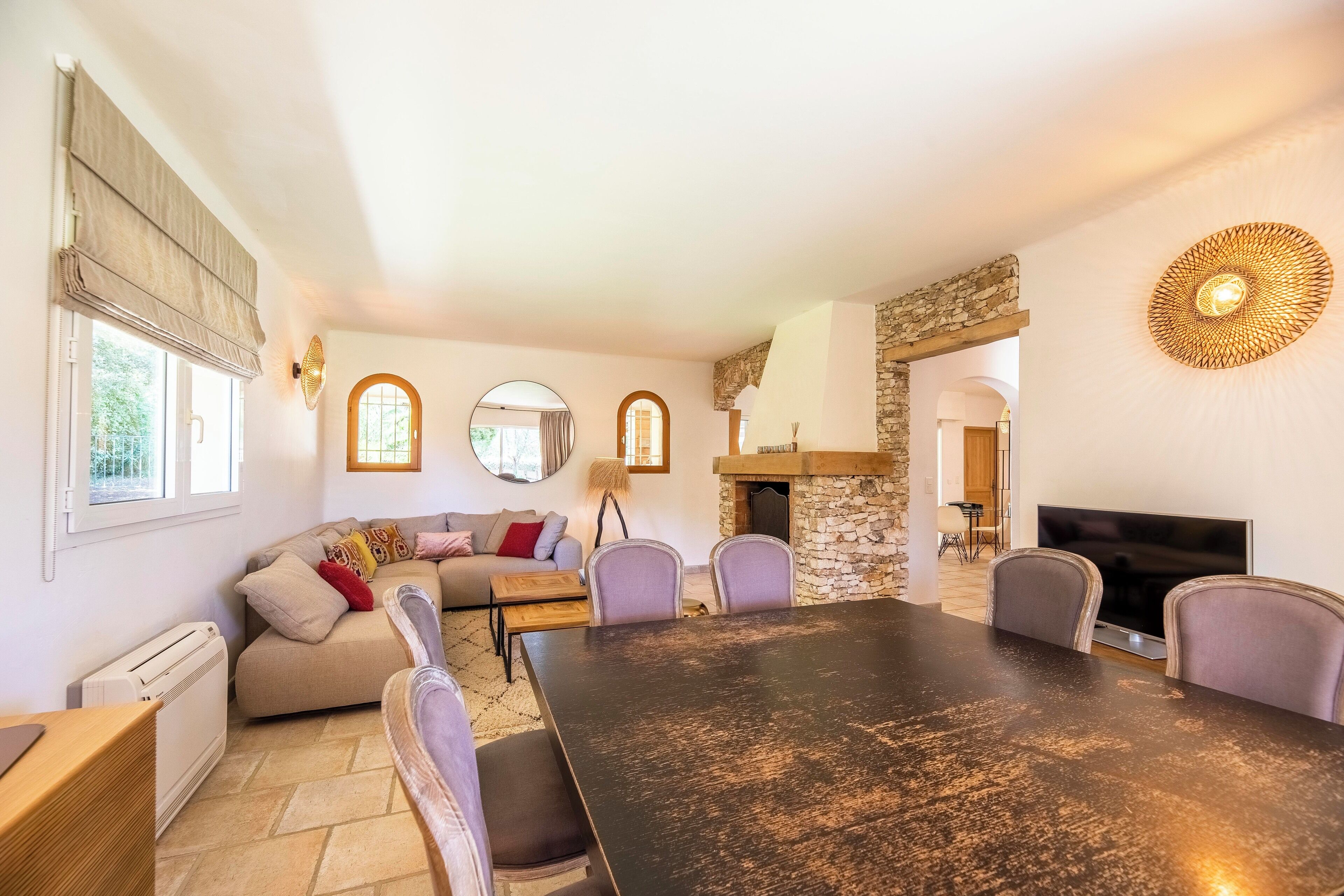 Una sala de estar acogedora con chimenea, una mesa de comedor y un sofá.