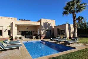 A modern pool area with lounge chairs and a palm tree. - Exceptional villa with private pool in Marrakech, Palmeraie area, Atlas view (Marrakech)