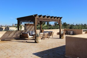 A rooftop patio with a pergola, outdoor furniture, and potted plants. - Exceptional villa with private pool in Marrakech, Palmeraie area, Atlas view (Marrakech)