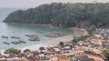 A coastal village with numerous boats docked along the shore and densely packed, low-rise buildings.