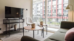 A modern living room with a TV, a sofa, a chair, and a table. - Modern Flat Heart of Providencia Lifestyle (Providencia)