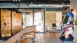 A modern interior with a curved counter, bar stools, and a retro arcade machine. - Modern Flat Heart of Providencia Lifestyle (Providencia)