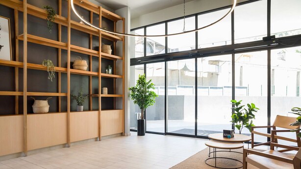 A modern interior with wooden shelving, potted plants, and a seating area by a large window. - Modern Flat Heart of Providencia Lifestyle (Providencia)