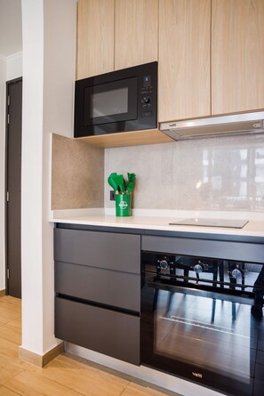Una cocina moderna con microondas, un organizador de utensilios verde y lavavajillas.
