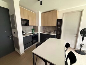Eine moderne Küche mit Holzausstattung, einem schwarzen Ofen und einer weißen Arbeitsplatte.