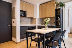 Une cuisine moderne avec une table à manger, des chaises et un vase rempli de fleurs.