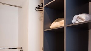 Ein begehbarer Kleiderschrank mit offenen Regalen und einer Kleiderstange.