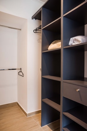 Un dressing avec des étagères ouvertes et une tringle pour suspendre les vêtements.