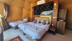 Ein Schlafzimmer mit zwei Betten, einem Holzkopfende, einem Nachttisch und Blick ins Freie.