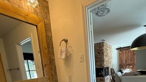 A bathroom with a large mirror, two sinks, and a towel rack. - Pendleton Lodge | Bring Your Boat | Near Lake Conroe (Conroe)