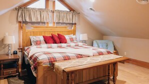 Un dormitorio con cama de madera, ropa de cama escocesa y un banco.