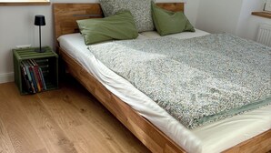A neatly made bed with a patterned bedspread, a wooden headboard, and two pillows. - Charming Leseloft vacation apartment in Tiengen (Waldshut-Tiengen)