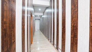 A hallway with wooden paneling and a marble floor. - RK Dham Family Hotel Free Parking (Vrindavan)