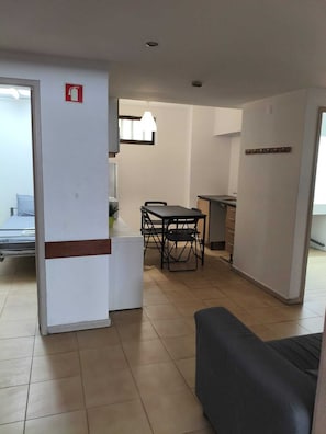 Un apartamento moderno con comedor, kitchenette y cama.