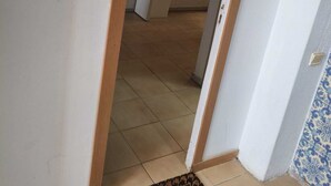 An interior view of a room with a door leading to a kitchen area. - Porto Central Hostel (Porto)