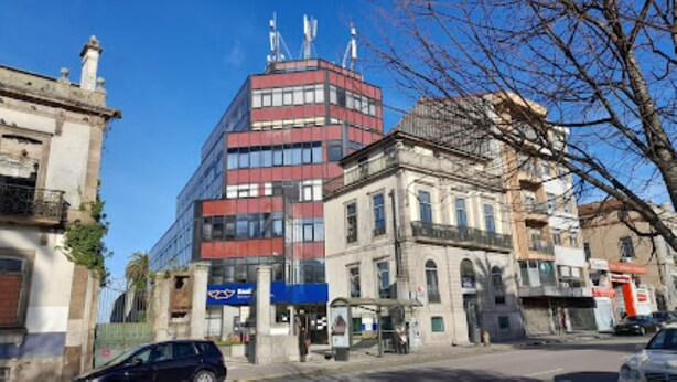 A street view with a modern building, a bank, and a bus stop. - Porto Central Hostel (Porto)