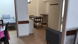 A room with a bed, a dining table with chairs, a small kitchen area, and a sofa. - Porto Central Hostel (Porto)