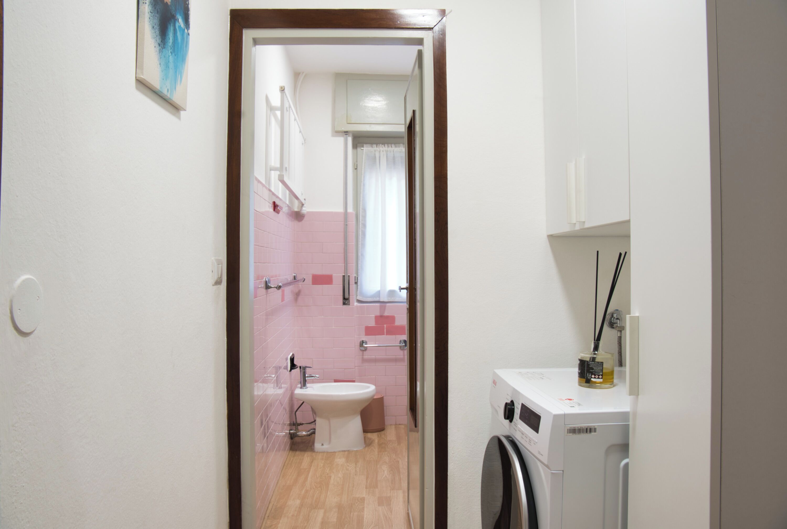 Ein Badezimmer mit Waschmaschine, Waschbecken und Toilette.