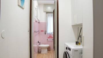 Ein Badezimmer mit Waschmaschine, Waschbecken und Toilette.