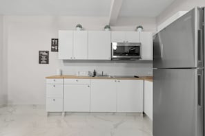 Apartamento família | Cozinha privada | Geladeira, micro-ondas, cooktop, talheres/pratos/utensílios de cozinha
