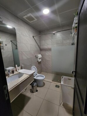 A modern bathroom with a shower, toilet, and sink. - Eliana Hotel (Al Khobar)