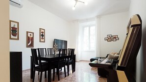 Ein Essbereich mit Tisch und Stühlen, einem Fernseher und einem Gemälde an der Wand.
