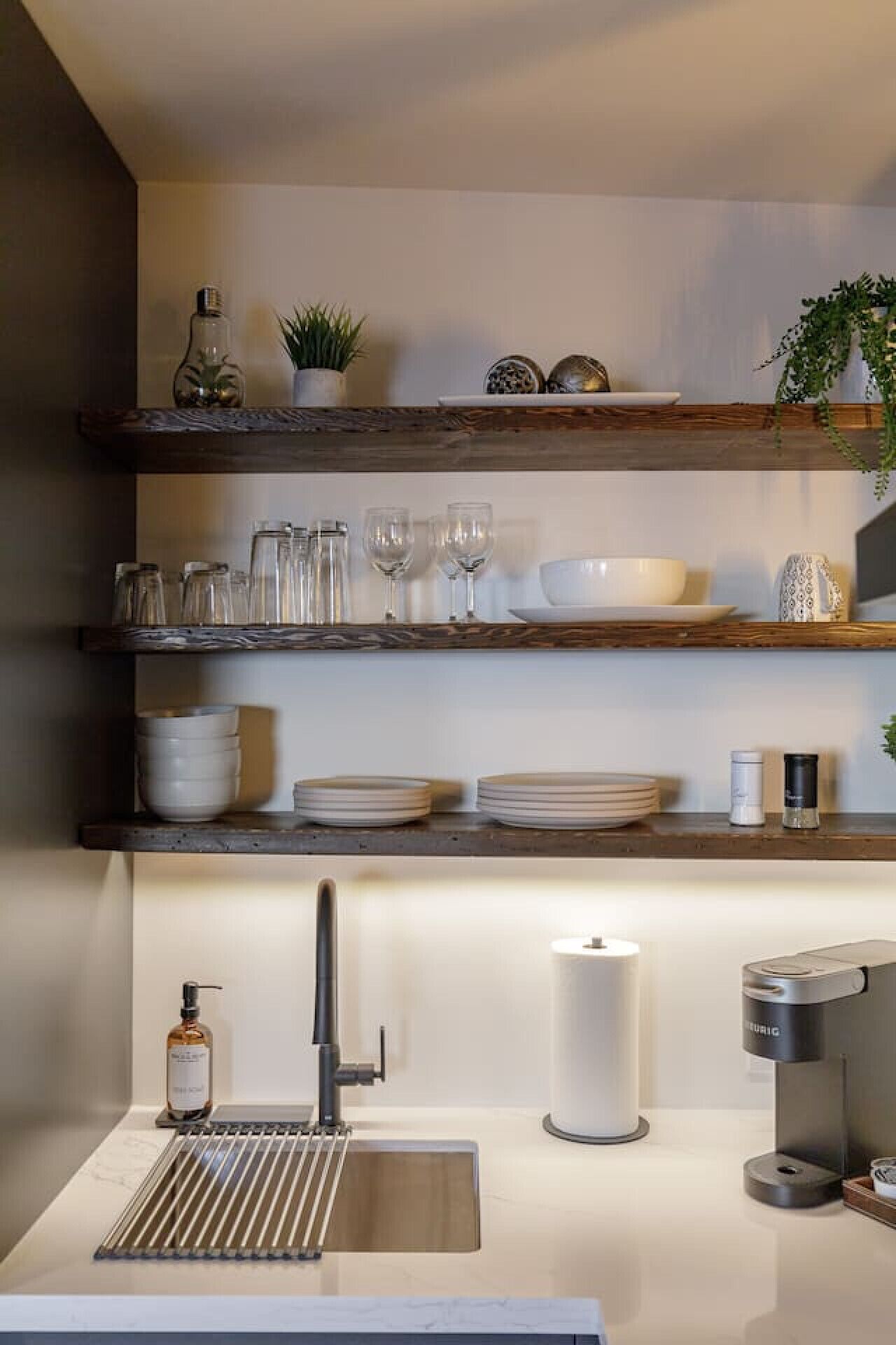 Een moderne keuken met houten planken, een roestvrijstalen spoelbak en een koffieapparaat.