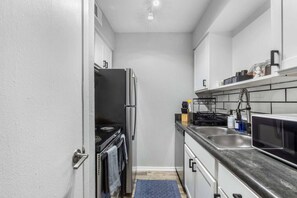 A compact kitchen with a stove, refrigerator, microwave, and sink. - 0.2mi/0.3km to Dallas Stadium 1BR +FREE Parking (Arlington)