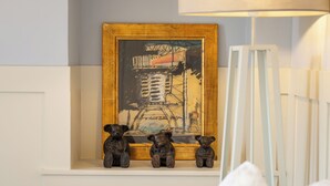 A bedroom with a bed, a bedside lamp, a framed artwork, and two small bear figurines on a shelf. - Maison Carei perched on the heights of Menton (Castellar)