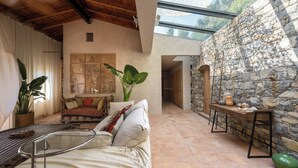 A cozy interior with a stone wall, a wooden ceiling, and a glass ceiling allowing natural light. - Maison Carei perched on the heights of Menton (Castellar)