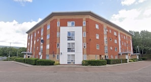 A multi-story residential building with a flat roof, rectangular windows, and satellite dishes. - Modern 2BDR Flat in East London Near Beckton DLR (Greater London)