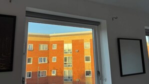 Porta aperta che dà su un edificio in mattoni con diverse finestre.