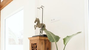 Una stanza con un armadio in legno, un cesto di vimini e una pianta grande.