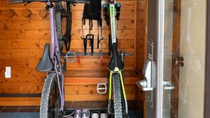 Une pièce aux murs en bois, avec un porte-vélo et une porte dotée d’un panneau en verre.
